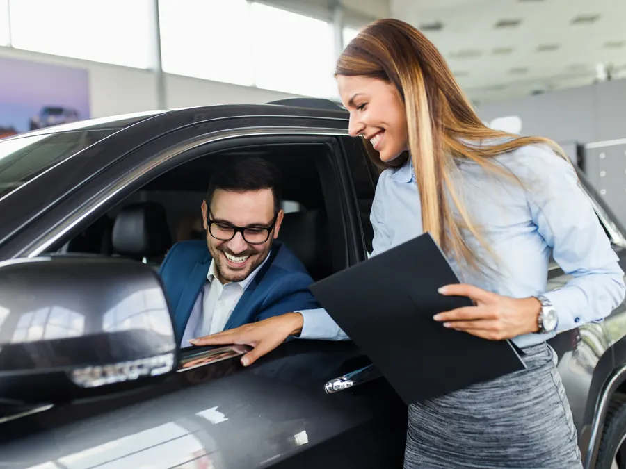 A salesperson helping a customer choose a car.