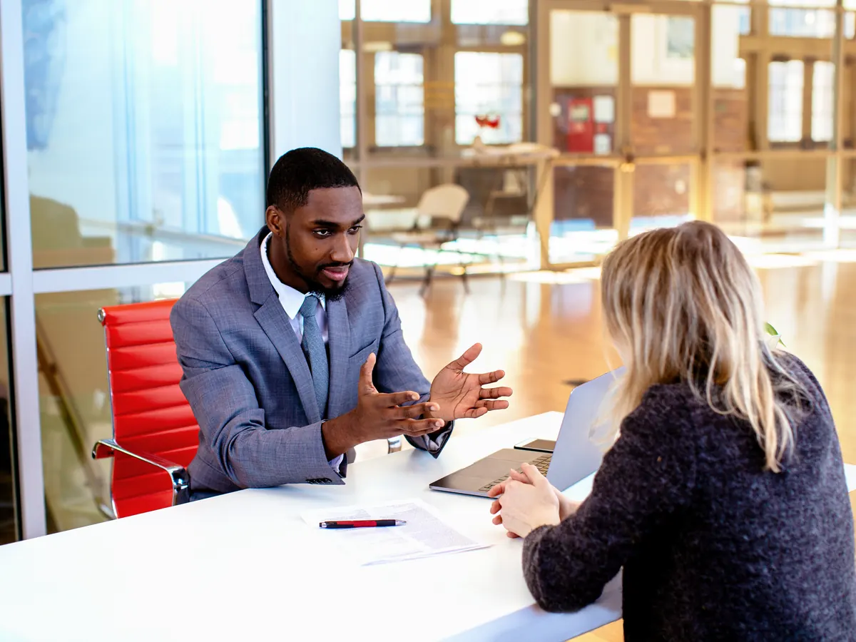 A lawyer explaining a document to a client in an office.