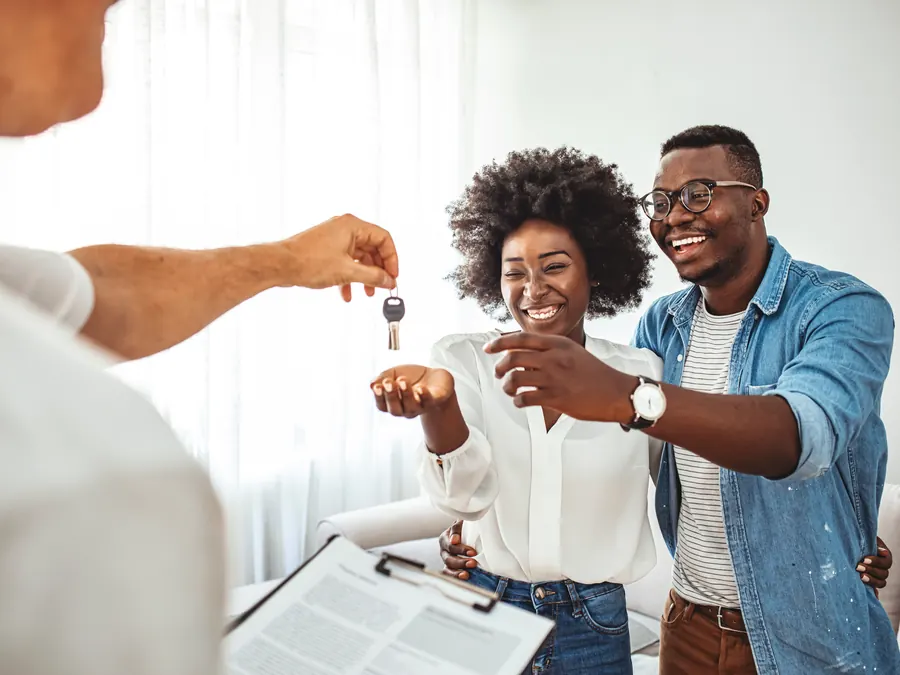 An agent handing a couple the keys to their new home.