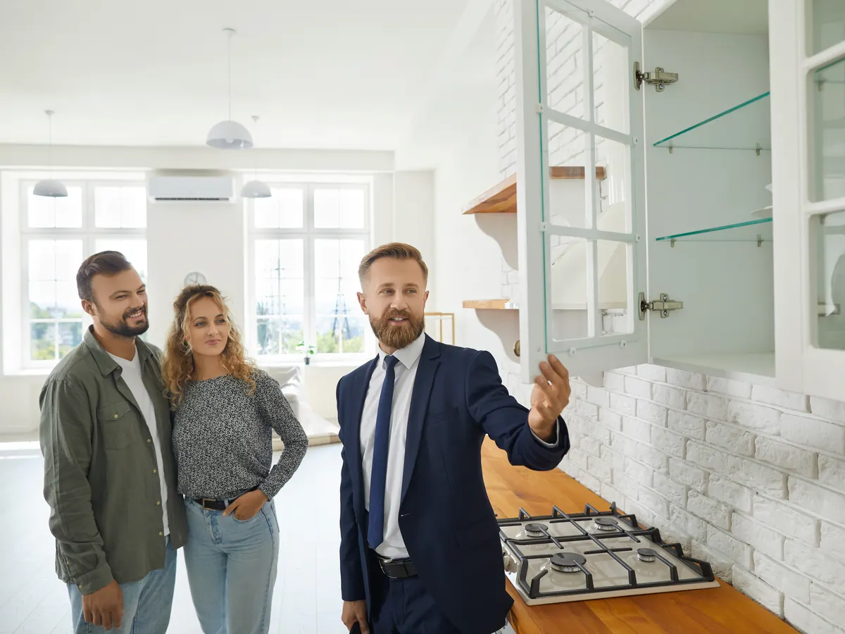 A real estate agent showing a couple around a home.