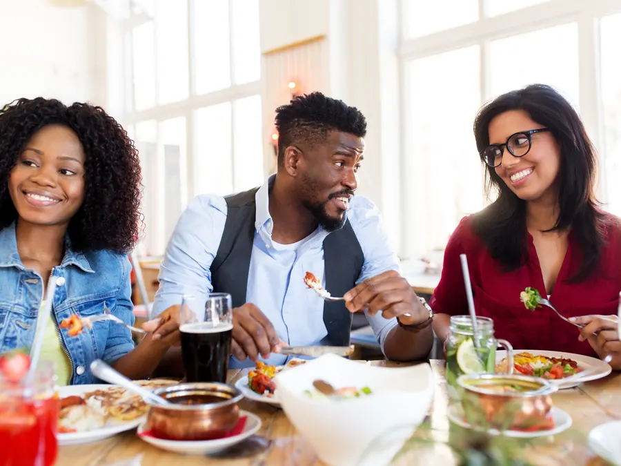 Friends sharing a meal at a restaurant table.