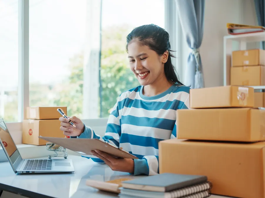 A shop owner packing online orders.