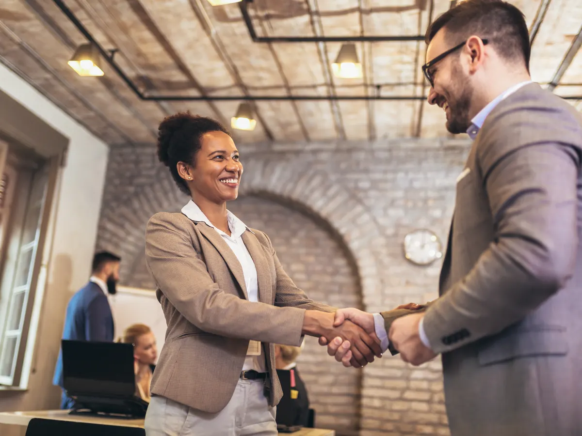 Two business people shaking hands in an office.