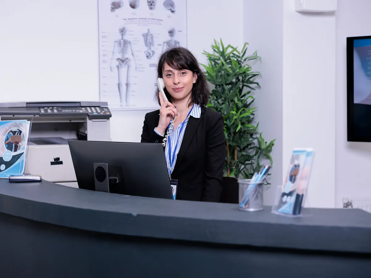 A receptionist answering a call at the front desk.