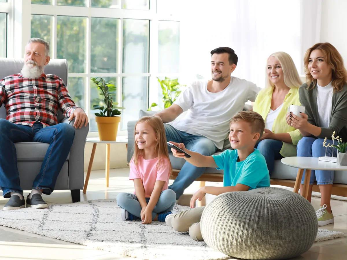A family watching TV together in their living room.