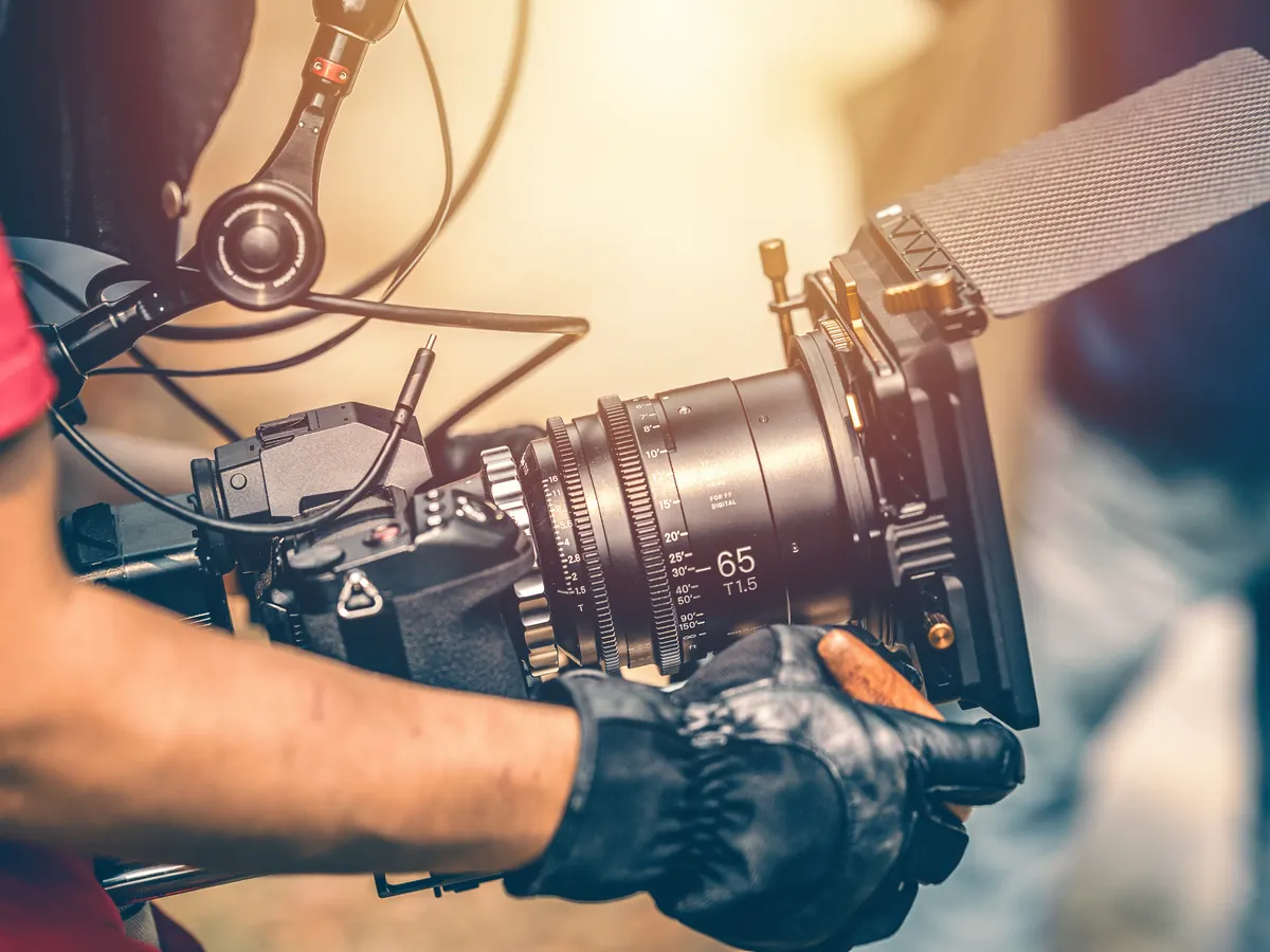 A camera operator with a cinema camera on a film set.