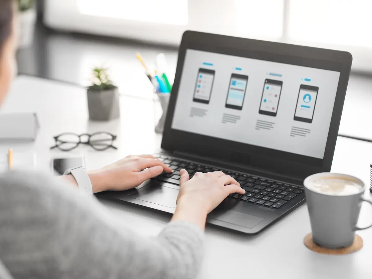 A web designer working on page layouts on a laptop.