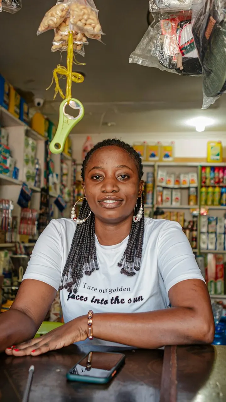 A shop owner smiling behind the counter.